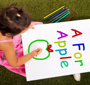 Little Girl Concentrating On Drawing A Picture With Multicolored Pencils